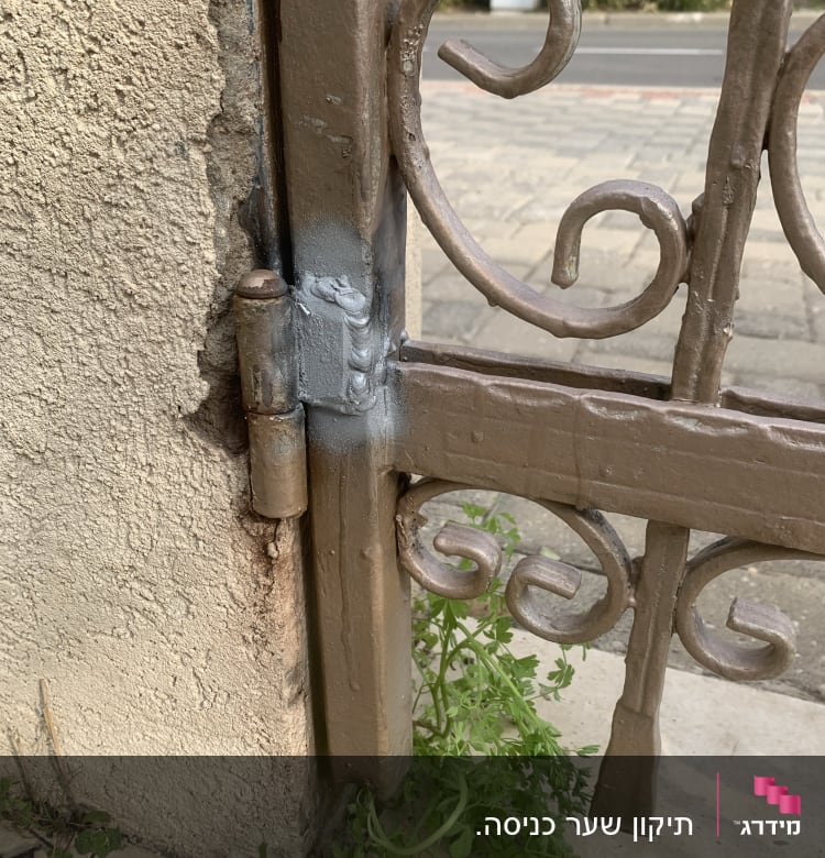 שער מתכת עם עיטורים, צמוד לקיר בטון